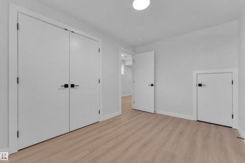 Unfurnished bedroom featuring light wood-style flooring and a closet - 9531/ 9533 115 Ave, Edmonton, AB - Indoor Photo Showing Other Room