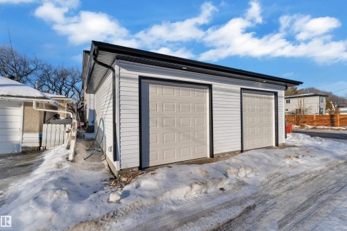Snow covered garage featuring a garage - 9531/ 9533 115 Ave, Edmonton, AB - Outdoor With Exterior