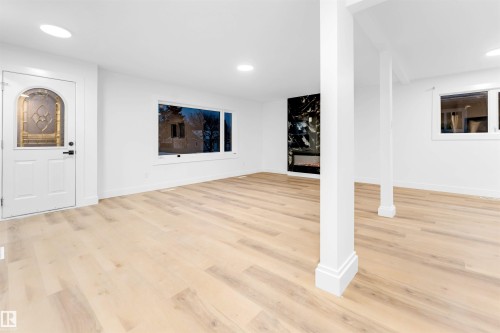 Unfurnished living room featuring light wood-type flooring, a fireplace, and recessed lighting - 7303 130 Avenue, Edmonton, AB - Indoor