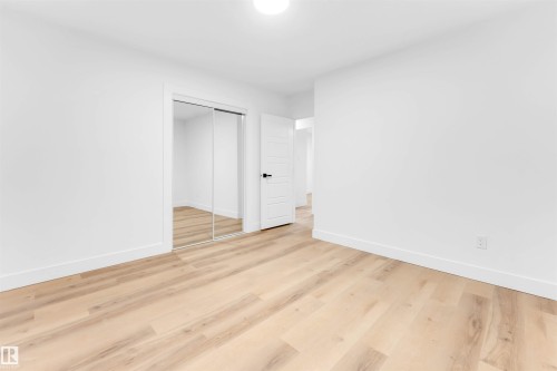 Unfurnished bedroom featuring a closet and light wood-style flooring - 7303 130 Avenue, Edmonton, AB - Indoor Photo Showing Other Room
