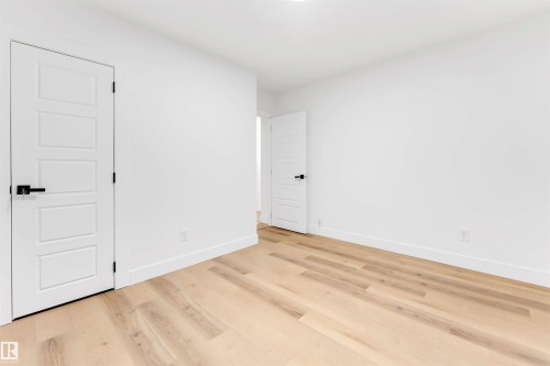 Unfurnished bedroom with light wood finished floors and baseboards - 7303 130 Avenue, Edmonton, AB - Indoor Photo Showing Other Room