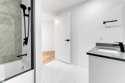 Bathroom featuring vanity, shower / bath combination with glass door, and light marble finish flooring - 7303 130 Avenue, Edmonton, AB - Indoor Photo Showing Bathroom