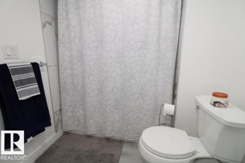 Full bathroom featuring a shower with shower curtain and wood finished floors - 22140 81 Avenue, Edmonton, AB - Indoor Photo Showing Bathroom