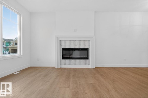 Detailed view of wood finished floors and a glass covered fireplace - 47 River Birch Way, St. Albert, AB - Indoor Photo Showing Living Room