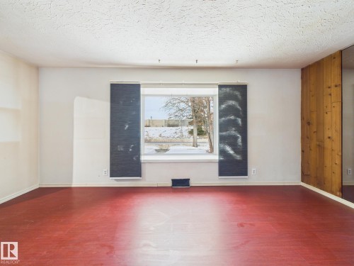 Unfurnished room featuring wood finished floors and a textured ceiling - 13523 124B Avenue, Edmonton, AB - Indoor Photo Showing Other Room