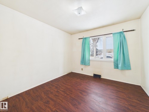 Spare room featuring dark wood-style floors and baseboards - 13523 124B Avenue, Edmonton, AB - Indoor Photo Showing Other Room
