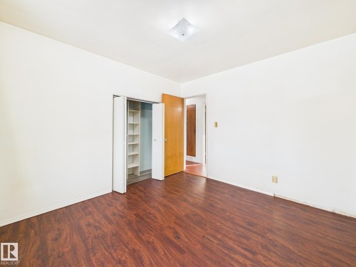 Unfurnished bedroom featuring dark wood-type flooring and a closet - 13523 124B Avenue, Edmonton, AB - Indoor Photo Showing Other Room