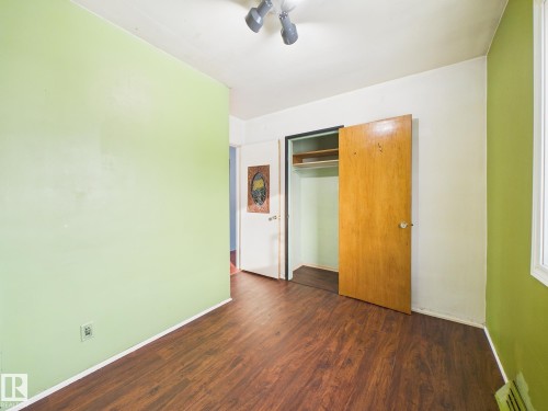 Unfurnished bedroom with dark wood-type flooring, a closet, and a ceiling fan - 13523 124B Avenue, Edmonton, AB - Indoor Photo Showing Other Room