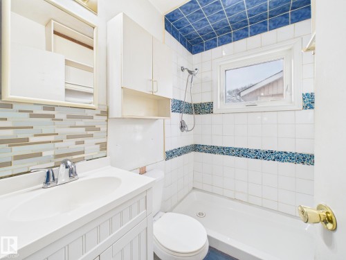 Bathroom featuring a tile shower, vanity, and decorative backsplash - 13523 124B Avenue, Edmonton, AB - Indoor Photo Showing Bathroom