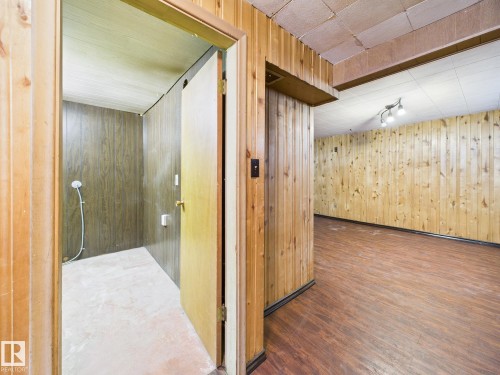 Hall with wooden walls and dark wood-style floors - 13523 124B Avenue, Edmonton, AB - Indoor Photo Showing Other Room