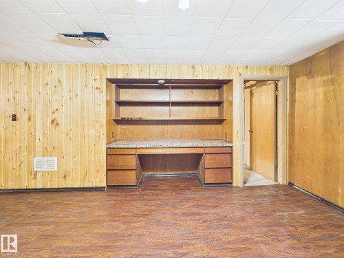 Unfurnished office with built in study area, dark wood-type flooring, and wood walls - 13523 124B Avenue, Edmonton, AB - Indoor Photo Showing Other Room