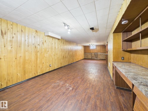 Basement featuring dark wood-style flooring and wood walls - 13523 124B Avenue, Edmonton, AB - Indoor Photo Showing Other Room