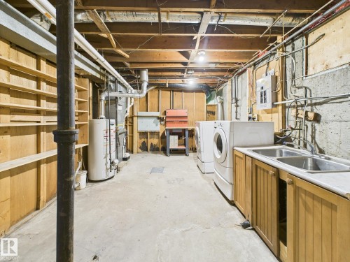 Unfinished basement featuring water heater, electric panel, separate washer and dryer, and heating unit - 13523 124B Avenue, Edmonton, AB - Indoor Photo Showing Laundry Room