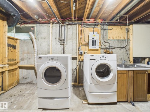 Laundry area with unfinished concrete floors, washing machine and dryer, and electric panel - 13523 124B Avenue, Edmonton, AB - Indoor Photo Showing Laundry Room