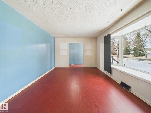 Unfurnished room with dark wood-style floors and a textured ceiling - 13523 124B Avenue, Edmonton, AB - Indoor Photo Showing Other Room