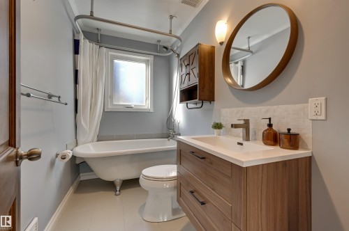 Full bathroom featuring a combined bath / shower with freestanding tub, tasteful backsplash, crown molding, vanity, and light tile patterned flooring - 10911 66 Avenue, Edmonton, AB - Indoor Photo Showing Bathroom