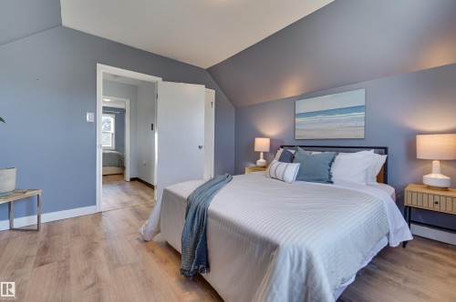 Bedroom featuring light wood-style flooring, vaulted ceiling, and a baseboard heating unit - 10911 66 Avenue, Edmonton, AB - Indoor Photo Showing Bedroom