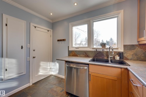 Kitchen featuring dishwasher, dark stone finish flooring, crown molding, recessed lighting, and backsplash - 10911 66 Avenue, Edmonton, AB - Indoor Photo Showing Kitchen With Double Sink