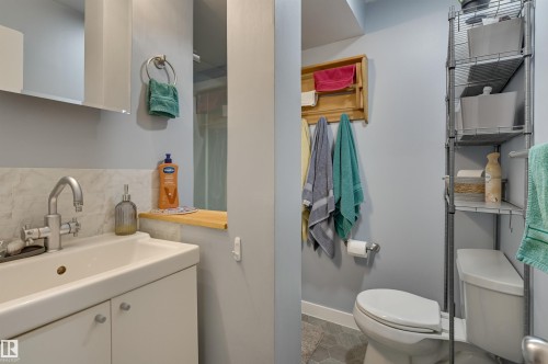 Bathroom featuring vanity and decorative backsplash - 10911 66 Avenue, Edmonton, AB - Indoor Photo Showing Bathroom