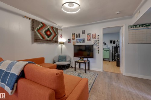 Living room featuring light wood finished floors and baseboards - 10911 66 Avenue, Edmonton, AB - Indoor