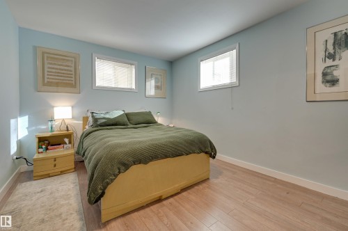 Bedroom with wood finished floors and baseboards - 10911 66 Avenue, Edmonton, AB - Indoor Photo Showing Bedroom