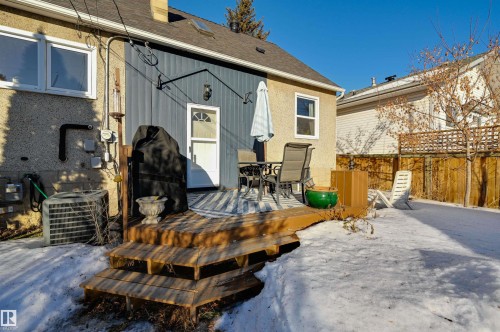 Snow covered property featuring outdoor dining area, roof with shingles, and a deck - 10911 66 Avenue, Edmonton, AB - Outdoor