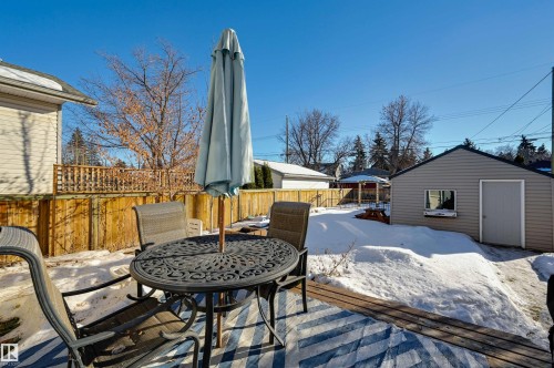 Snow covered deck with outdoor dining space, an outdoor structure, and a fenced backyard - 10911 66 Avenue, Edmonton, AB - Outdoor