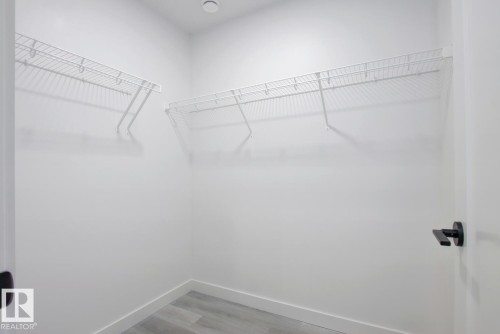 Walk in closet with light wood finished floors - 11016 132 Street, Edmonton, AB - Indoor With Storage