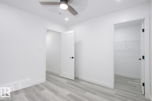 Unfurnished bedroom featuring a walk in closet, light wood-type flooring, ceiling fan, and recessed lighting - 11016 132 Street, Edmonton, AB - Indoor Photo Showing Other Room