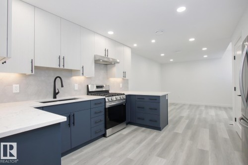 Dual tone kitchen featuring dual tone cabinetry, stainless steel gas stove, tasteful backsplash, light stone countertops, and recessed lighting - 11016 132 Street, Edmonton, AB - Indoor Photo Showing Kitchen With Upgraded Kitchen
