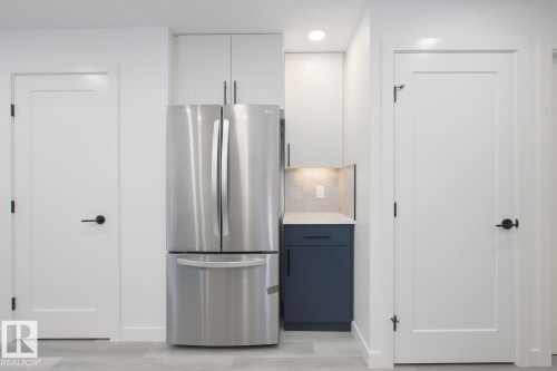 Kitchen with freestanding refrigerator, two tone cabinets, tasteful backsplash, light wood-style floors, and recessed lighting - 11016 132 Street, Edmonton, AB - Indoor