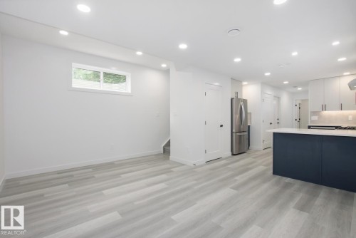Kitchen featuring recessed lighting, freestanding refrigerator, light wood-style floors, dual tone cabinets, and a peninsula - 11016 132 Street, Edmonton, AB - Indoor Photo Showing Kitchen With Upgraded Kitchen
