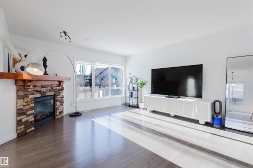 Unfurnished living room with hardwood / wood-style flooring and a fireplace - 3547 Mclay Crescent, Edmonton, AB - Indoor Photo Showing Living Room With Fireplace
