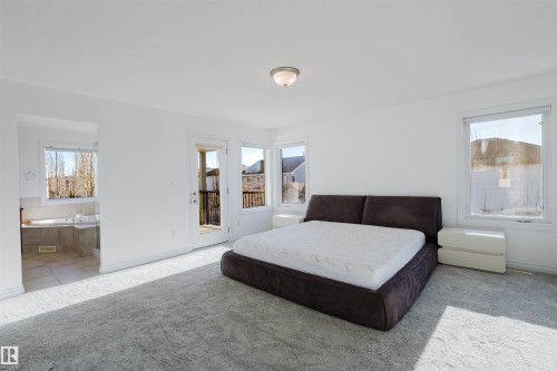 Carpeted bedroom featuring access to exterior and baseboards - 3547 Mclay Crescent, Edmonton, AB - Indoor Photo Showing Bedroom