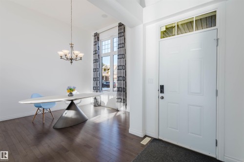 Foyer entrance featuring dark wood-style floors, a chandelier, and a high ceiling - 3547 Mclay Crescent, Edmonton, AB - Indoor