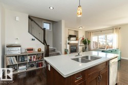 Kitchen with open floor plan, pendant lighting, dark wood-style floors, dark wood finish cabinetry, and a textured ceiling - 