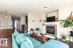 Living area featuring dark wood finished floors, a fireplace, and a textured ceiling - 
