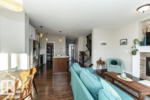 Living area featuring a stone fireplace, dark wood finished floors, and a textured ceiling - 10535 67 Avenue, Edmonton, AB - Indoor With Fireplace