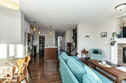 Living area featuring a stone fireplace, dark wood finished floors, and a textured ceiling - 