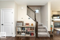 Stairs with wood-type flooring, a textured ceiling, and a stone fireplace - 