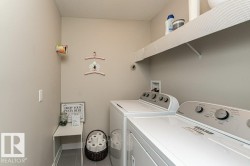 Laundry area featuring a textured ceiling, washer and clothes dryer, and tile patterned floors - 