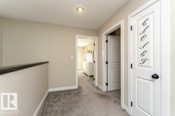 Hall with light colored carpet and baseboards - 
