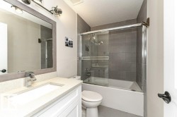 Bathroom with enclosed tub / shower combo, vanity, a textured ceiling, and tile patterned floors - 