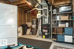 Unfinished below grade area featuring water heater and heating unit - 