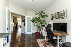 Office space featuring french doors, dark wood-style floors, and a textured ceiling - 