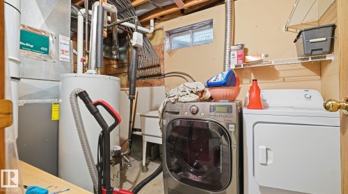 Laundry area with water heater, heating unit, and washer and dryer - 1509 Jarvis Cr, Edmonton, AB - Indoor Photo Showing Laundry Room