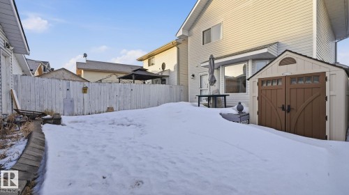 Yard covered in snow featuring a storage unit and a fenced backyard - 1509 Jarvis Cr, Edmonton, AB - Outdoor With Exterior