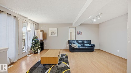 Living room with light wood-style floors, a textured ceiling, and track lighting - 1509 Jarvis Cr, Edmonton, AB - Indoor