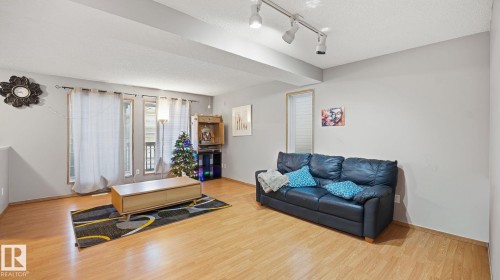 Living room with wood finished floors, a textured ceiling, and track lighting - 1509 Jarvis Cr, Edmonton, AB - Indoor Photo Showing Living Room