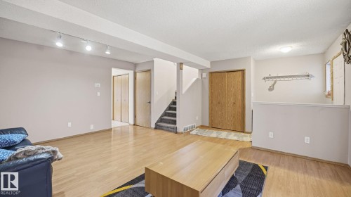 Living room with light wood-style floors, a textured ceiling, and track lighting - 1509 Jarvis Cr, Edmonton, AB - Indoor
